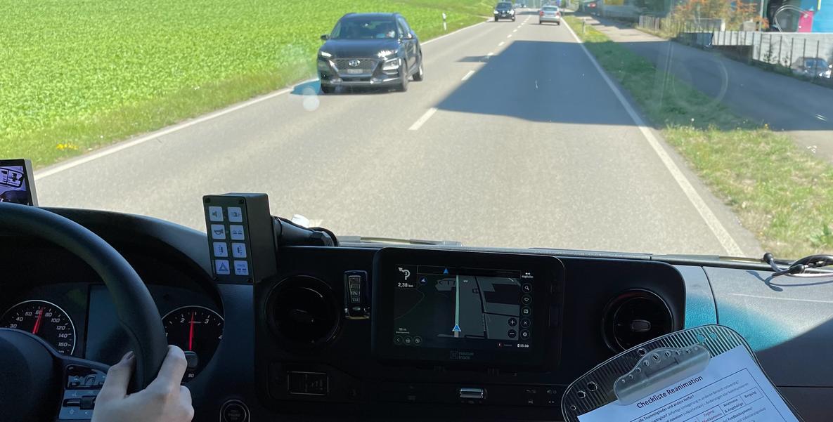 Blick aus dem Fahrerhaus eines Rettungswagens auf eine Landstrasse mit entgegenkommendem Auto